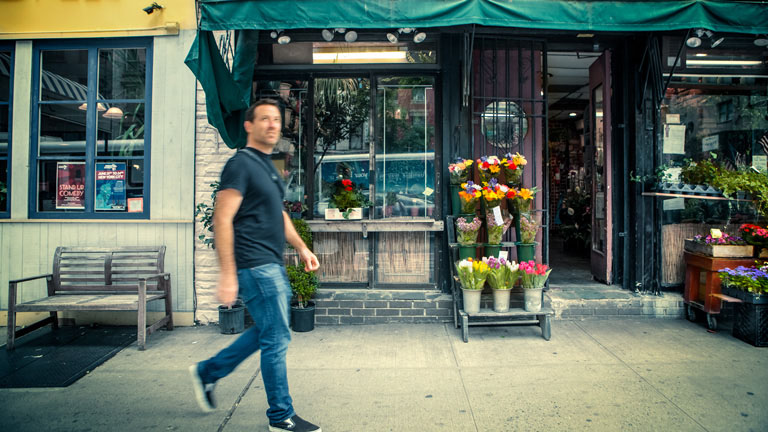 Andrew Farnsworth walks in front of a flower shop in NYC