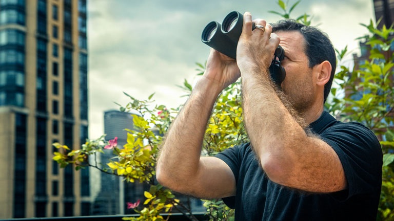 Andrew Farnsworth looks for birds through binoculars